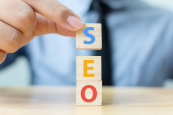 Search engine optimisation concept. Hand putting wood block cube shape with word SEO